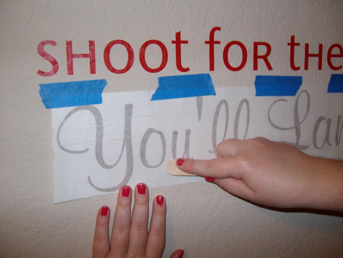 Second, you’ll do your 1st Rub. Use the applicator to rub the letters, with it still encased in the transfer paper. (It’s still a sandwich). My wall was highly textured, so I had to rub and rub and rub and rub.